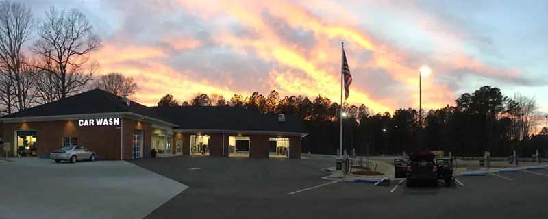 A MEGA Auto Spa location at sunset, with the Car Wash sign lit up
